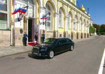 По российскому телевидению, демонстрирующую инаугурацию Владимира Путина, показали, как он вышел из Первого корпуса Кремля, где находится его рабочий кабинет, и сел в отечественный черный лимузин проекта "Кортеж", чтобы проехать в Большой Кремлевский дворец