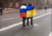 По центру Киева прогулялись двое мужчин, завернутые в российский и украинский флаги