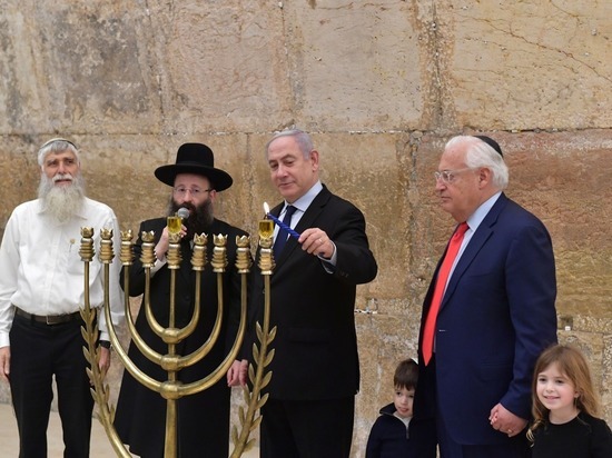 Премьер-министр Биньямин Нетаниягу и посол США в Израиле Дэвид Фридман зажгли первую ханукальную свечу у Стены Плача в Иерусалиме.