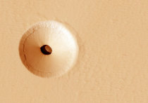 Специалисты, представляющие американское аэрокосмическое агентство NASA, показала фотографию, на которой можно увидеть довольно необычную деталь марсианского ландшафта — почти идеально круглое отверстие  на склоне бывшего марсианского вулкана под названием Гора Павлина