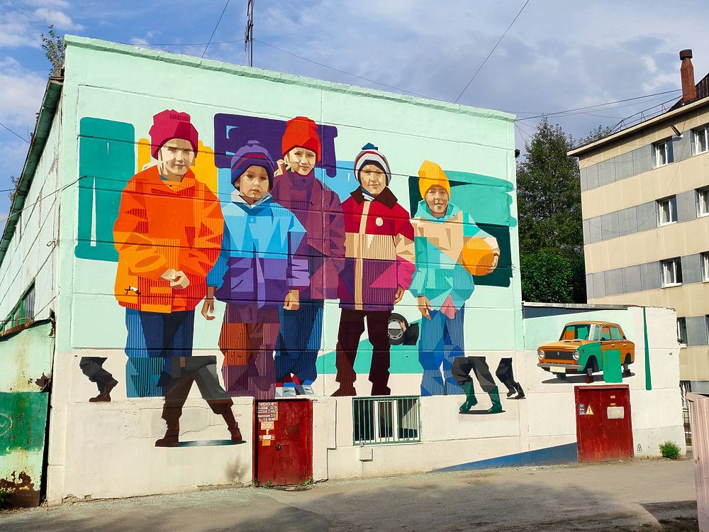 Рязанский уличный художник создал граффити с детьми 90-х в Тюмени