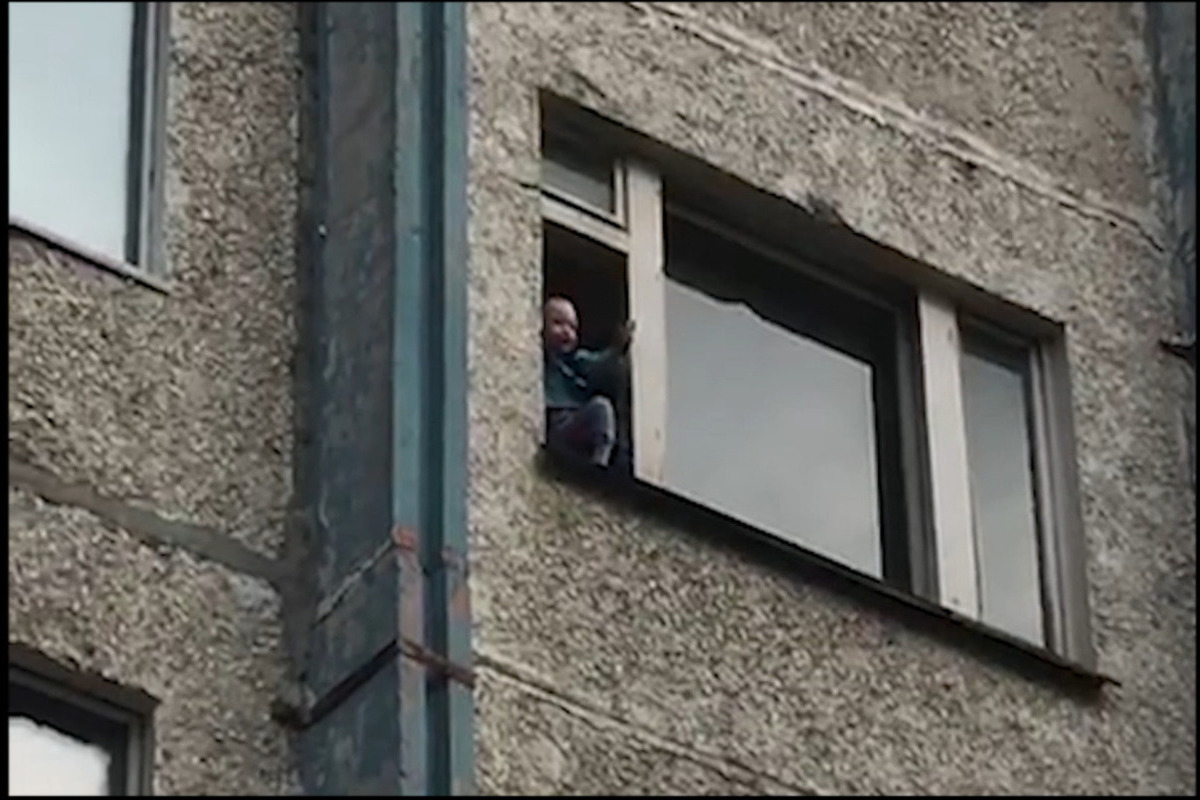 На ангарской улице неизвестный мужчина стоит в окне многоэтажки с ножом в руках