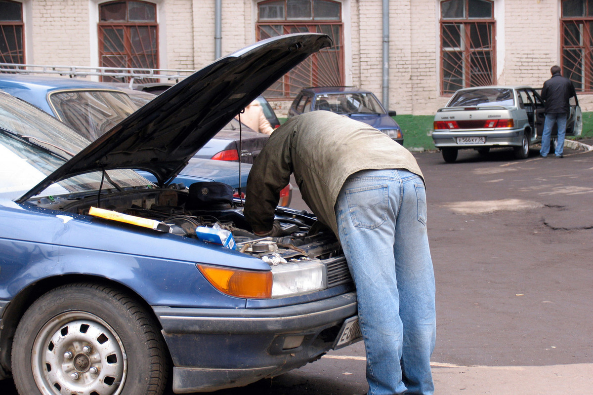 Ремонт автомобилей статьи. Человек чинит машину. Мужчина ремонтирует машину. Мужчина чинит машину. Мужик чинит тачку.