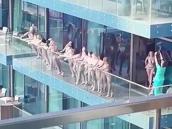 Более десятка голых девушек позировали голыми на балконе небоскреба