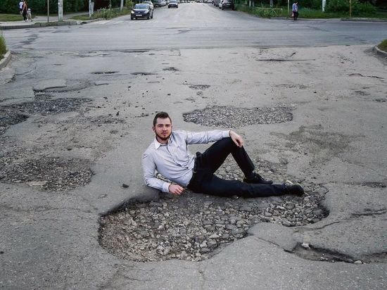Рязанец сфотографировался в огромной дорожной яме в Канищеве