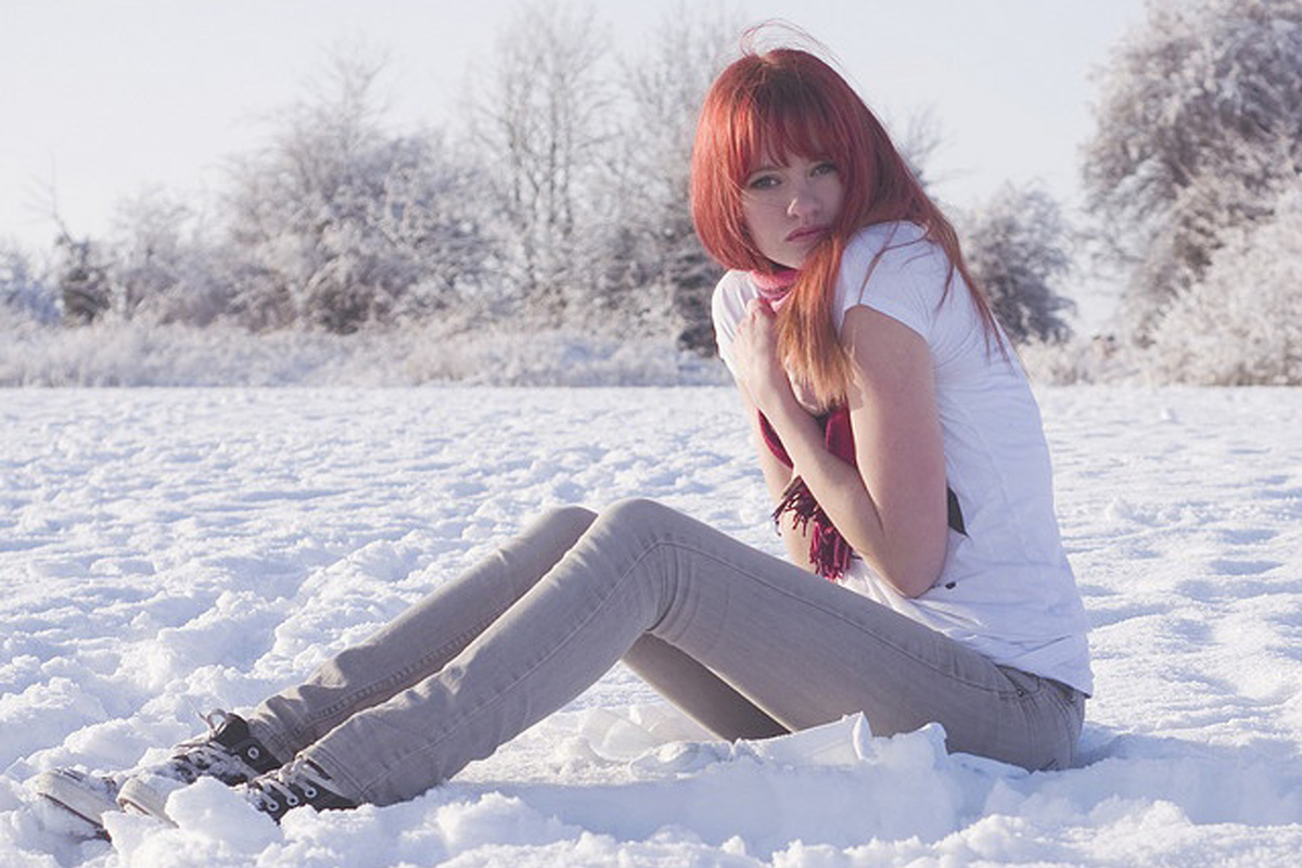 Сидит сугробе. Рыжая девушка зимой. Рыжая девушка в снегу. Замерзшая девушка.
