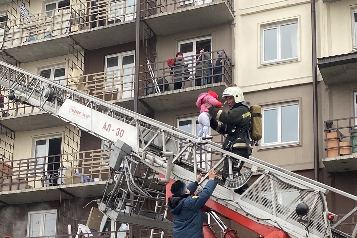 Спасательный дом. Пожарные спасают людей в многоэтажном доме. Вынос пожарного. Пожар в многоэтажном доме. Пожарная эвакуация.