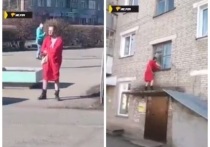 Бородатый мужчина в красном женском халате и с женской сумкой через плечо прогулялся по улицам города Куйбышева в Новосибирской области в воскресенье, 10 апреля