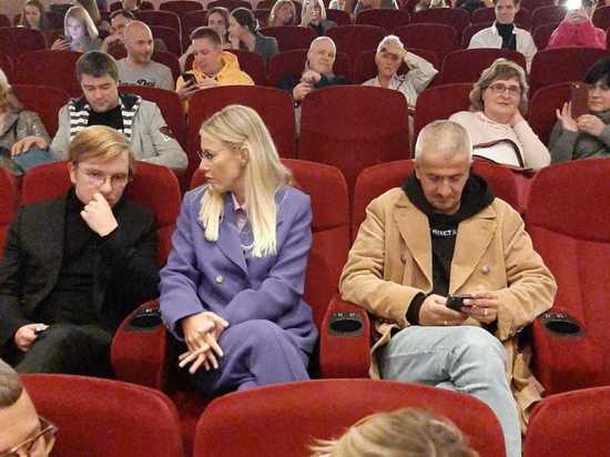 Жена бегала от журналистов, муж скрывал лицо мобильным телефоном