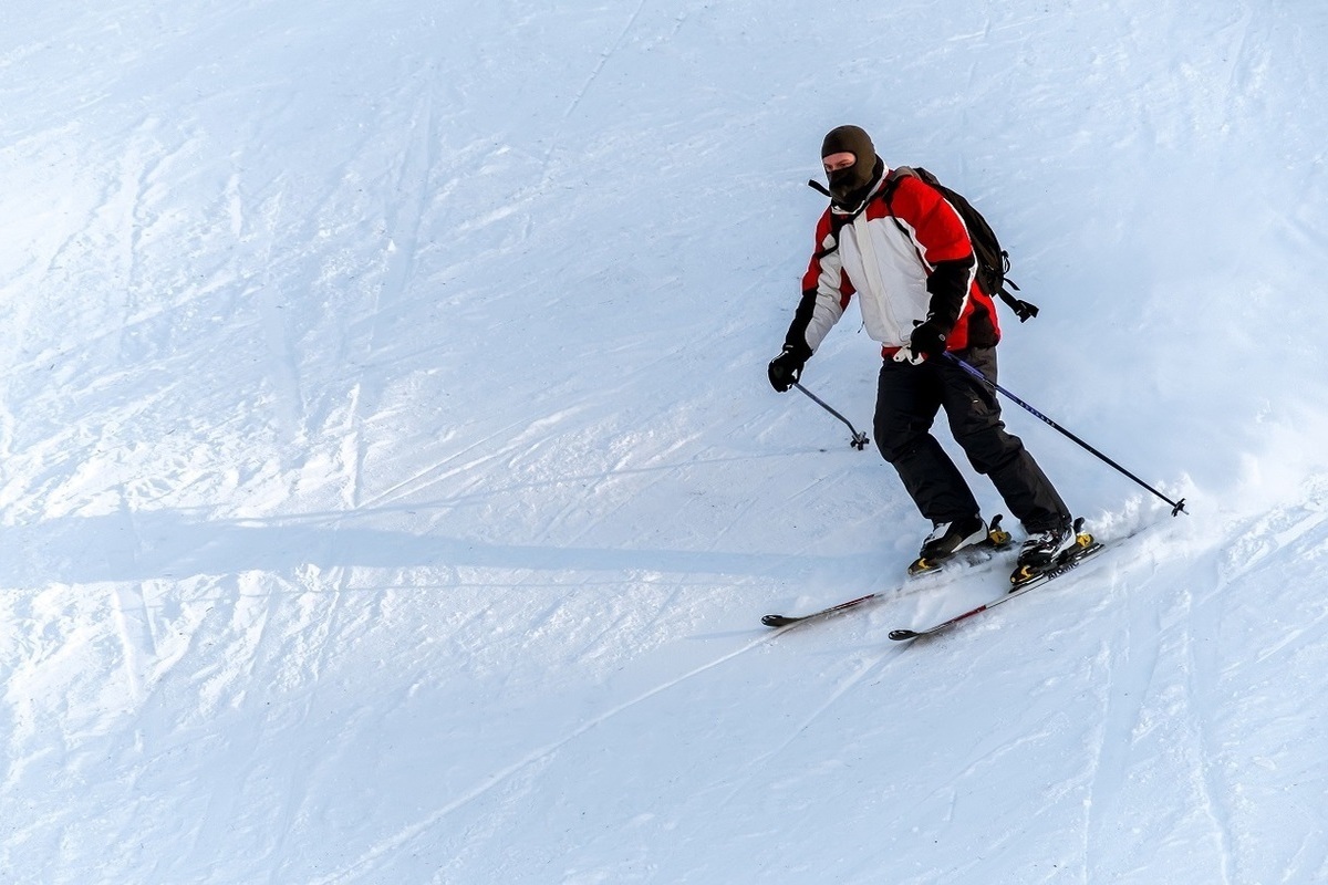 Skiing track. Лыжник. Замерзший лыжник. Спортсмен лыжник. Фото лыжника на фоне гор темный фон.
