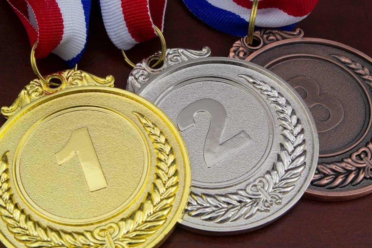 Спортсмен с медалью. Две медали. Медали несколько этапов. Золотая медаль чемпионата России.