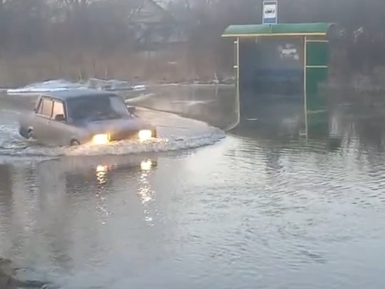 Остановочный павильон и дорога ушли под воду в кузбасском городе