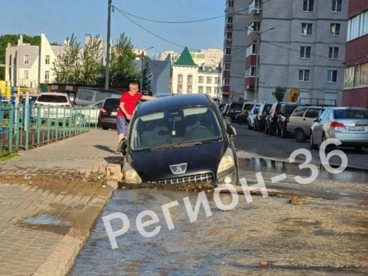 В воронежском ЖК «Ботанический сад» из-за коммунальной аварии иномарка Peugeot провалилась под асфальт