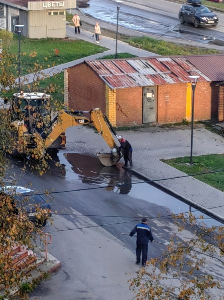 После дождя в Беломорске рабочие ведром вычерпывали воду из лужи