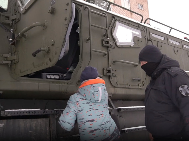 Новгородские росгвардейцы вручили мальчику подарок и прокатили его на броневике