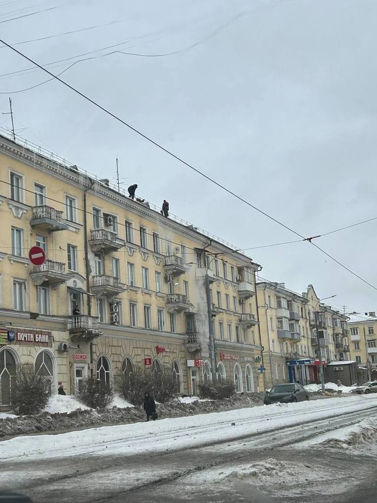  В Новокузнецке бесстрашные рабочие чистили снег с крыши без страховки