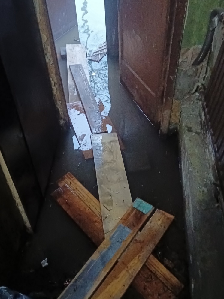 Подъезд в аварийном бараке в Петрозаводске затопило: люди проложили мостки