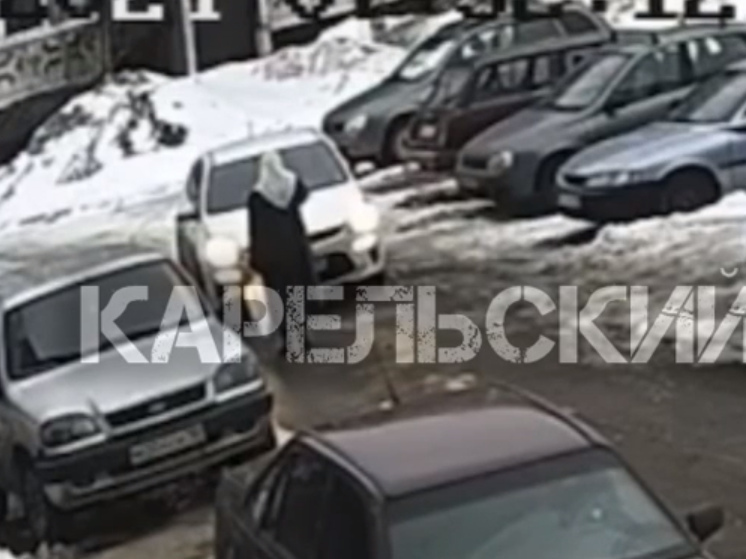 Неизвестная бабушка в платке крестит автомобили в Петрозаводске