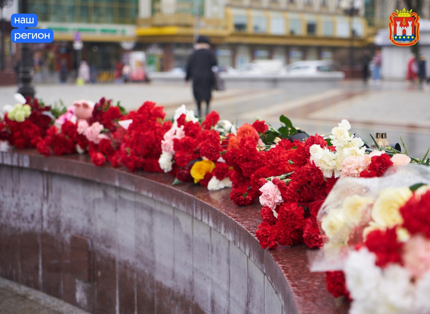 Калининградцы второй день подряд несут цветы и игрушки к стихийному мемориалу на площади Победы