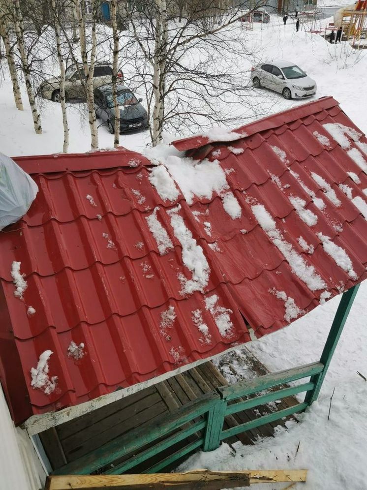 В Салехарде с крыши рухнул лед: поврежденный козырек крыльца может упасть на людей