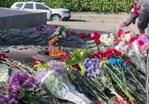 Жители Киева несут цветы к Вечному огню в парке Славы, сообщает украинское издание "страна