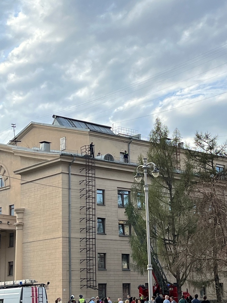 Мужчина стоит на краю крыши драмтеатра в Кемерове