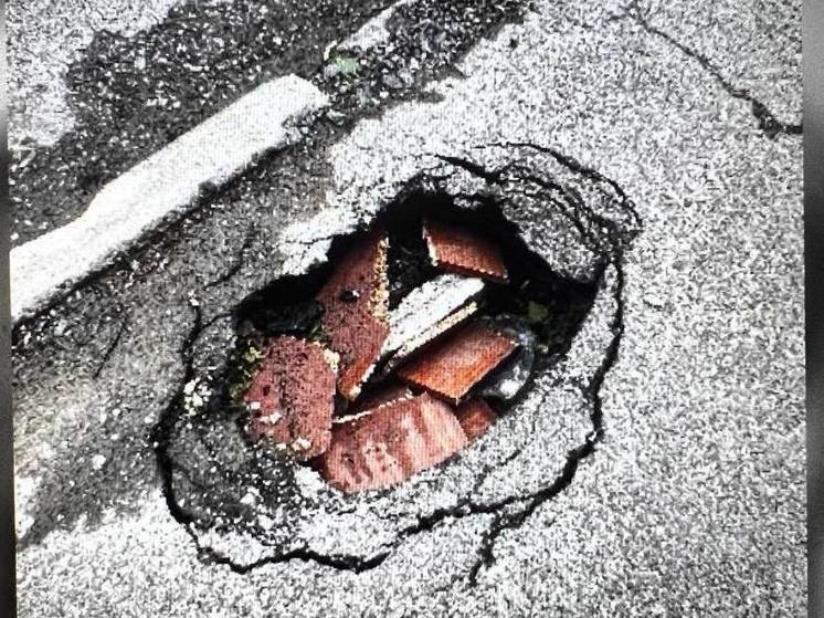 В Южно-Сахалинске опасную яму на тротуаре "отремонтировали" кусками ДСП