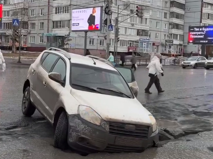 В центре Омска машина провалилась в огромную яму на дороге