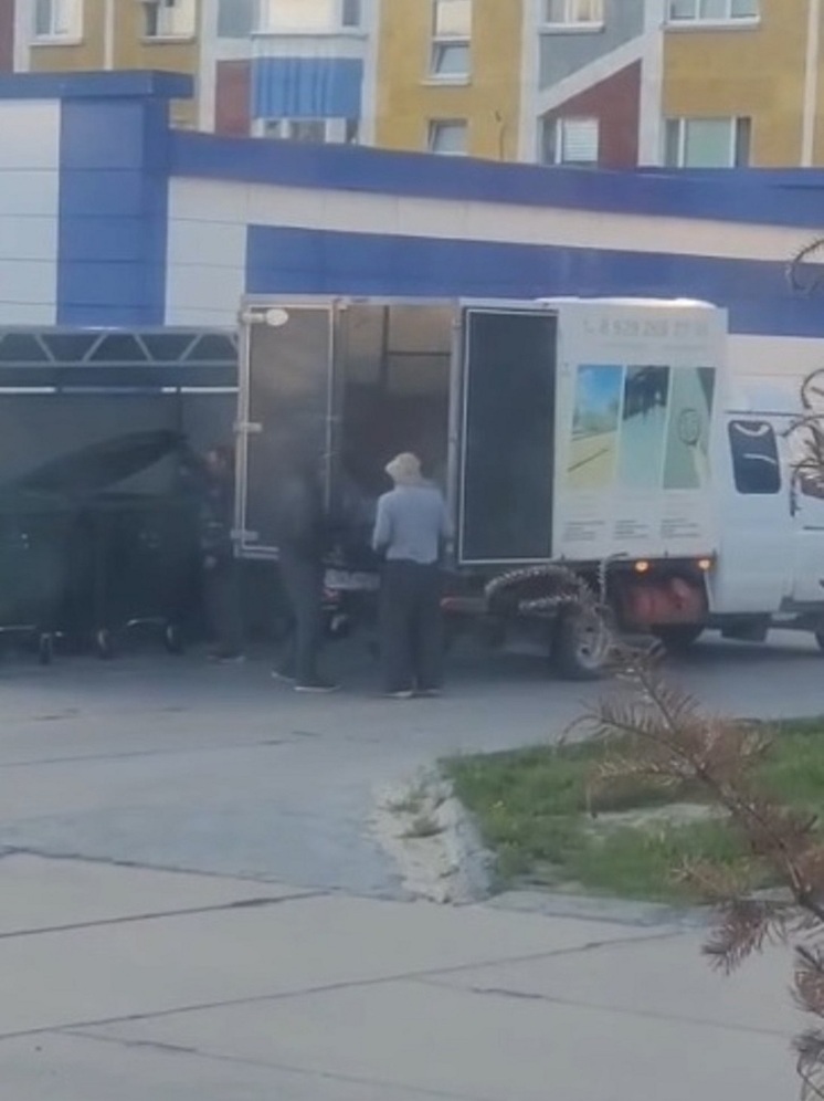 Жительница Надыма сняла на видеокамеру мобильного телефона момент, когда бригада рабочих выгружает в контейнеры для ТКО тяжелые мешки с бетоном