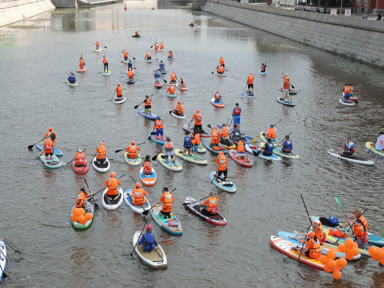 Varios participantes con coloridos disfraces en sus tablas de SUP