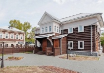 Деревянное двухэтажное здание в 130-м квартале, перед ним – аккуратные каменные дорожки, дворик с живописными фонарями