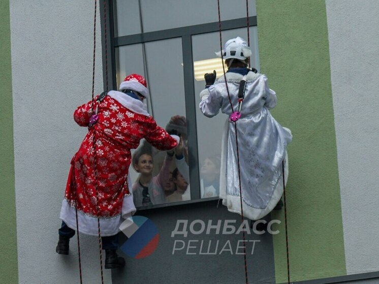 В Мариуполе Деды Морозы и Снегурочки спустились как альпинисты с крыши больницы и вручили подарки маленьким пациентам