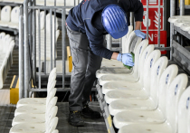 Строительство олимпийской хоккейной арены «Милано Сантаджулия» близится к завершению, однако остаются вопросы по функциональной готовности объекта к первому тестовому мероприятию 9–11 января 2026 года. НХЛ, согласившаяся предоставить игроков, оставляет за собой право пересмотреть решение при несоответствии качества льда. Размеры площадки (60×26 м) соответствуют стандартам ИИХФ, но отличаются от НХЛ. Окружающая территория — зона реконструкции с незавершённой инфраструктурой.