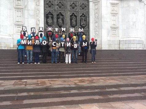 Участники акции в балаклавах развернули плакат "Блаженны милостивые"