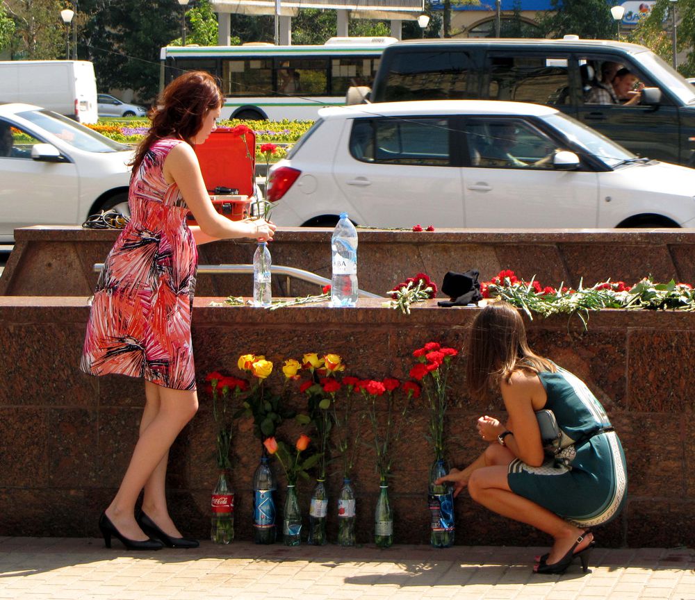 Люди несут цветы к месту трагедии